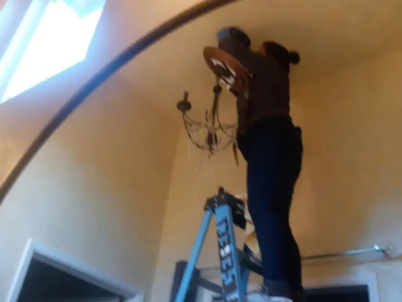 Electrician installing a chandelier in a Pollock Pines residence